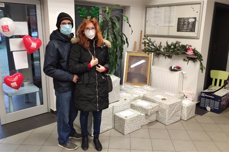 kobieta i mężczyzna stoją prze kilkunastoma kolorowo zapakowanymi kartonami