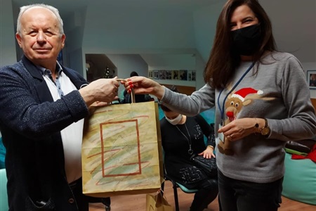 mężczyzna prezentuje papierową torbę którą wręczyła mu kobieta