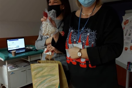 kobieta prezentuje świeczkę w kształcie choinki, którą wyjęła z torby prezentowej